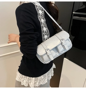 Detail of grey glossy PU underarm bag with double front pockets and metallic buckles