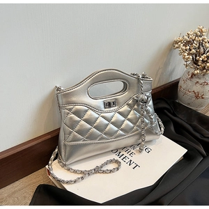 Detail of silver quilted bucket bag with metallic finish and silver chain strap