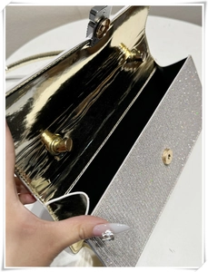 Close-up of evening clutch bag showing silver glitter exterior and gold mirror lining