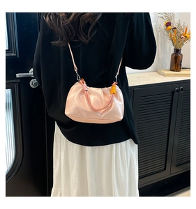 Detail of light pink pleated cloud bag with unique yellow and pink braided rope handle