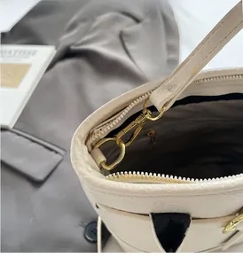 Macro detail of high-quality gold hardware and zipper on the beige leather handbag