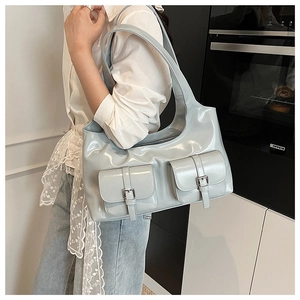 Close-up of light blue glossy leather shoulder bag with silver buckle flap pockets