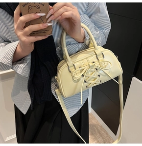 Dettaglio della borsa in pelle PU giallo crema con esclusivo design stringato a corsetto