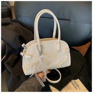 Détail du sac Boston crème avec nœud en perles, rubans dentelle et couture tressée