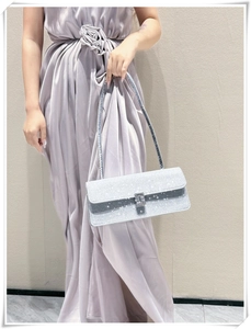 Detail of silver rhinestone baguette bag featuring a crystal buckle and metallic strap