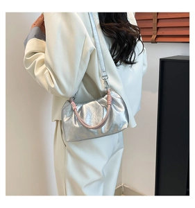 Detail of silver metallic pleated cloud bag with pink and white woven handle and thin strap