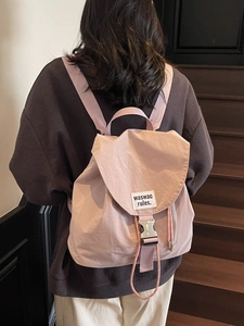 Pink drawstring nylon backpack with metal buckle closure and vertical side zipper pocket
