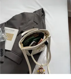 Detail of beige leather bucket bag interior showing space for phone and makeup accessories