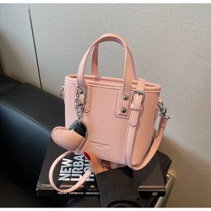 Detailed macro view of pink litchi grain leather bucket bag with silver metal rivets