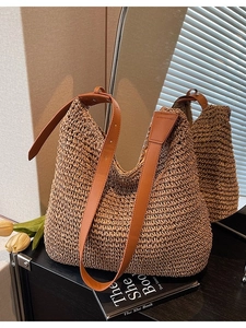 Large straw woven tote bag with adjustable brown leather shoulder strap for beach and travel