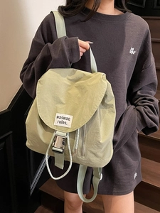 Matcha green nylon drawstring backpack with buckle flap and white text label for women