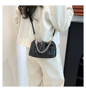 Detail of black pleated cloud bag featuring woven handle and silver hardware