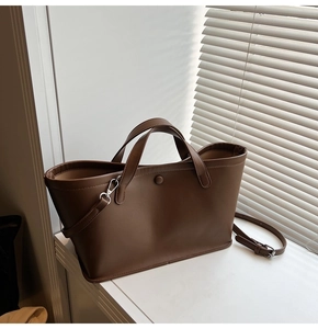 Detail view of the brown minimalist tote bag texture with adjustable strap and handles