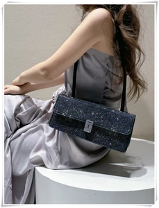 Close-up of luxury black rhinestone shoulder bag on a model wearing a purple dress