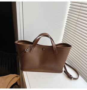 Detailed view of deep brown bucket bag showing premium PU leather texture and strap