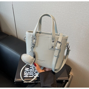 Detail of mint green bucket bag with lychee texture leather and heart-shaped charm