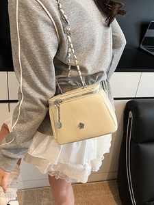 Fashionable creamy yellow mini chain bag with silver floral logo and quilted texture