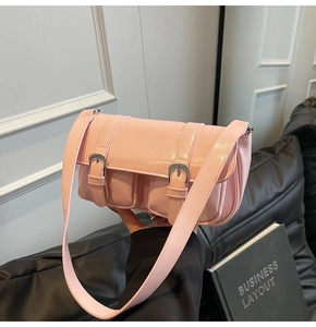Close-up of pink PU leather crossbody bag with dual front pockets and silver buckles