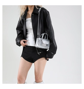 Silver metallic mini crossbody bag shown on a model with black leather jacket