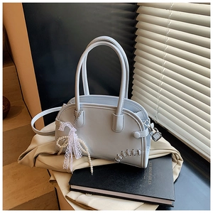 Détail du sac fourre-tout bleu clair en similicuir avec perles et nœud en dentelle