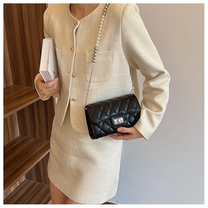 Détail du sac à bandoulière matelassé noir avec chaîne de perles et fermoir sur modèle