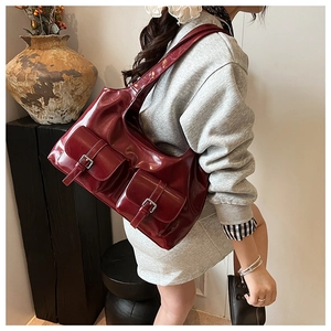 Detail of dark red hobo bag with silver buckles shown in a retro interior setting