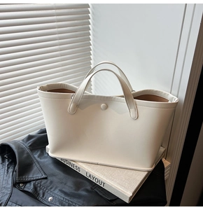 Close-up of a minimalist cream white tote bag on leather and linen background