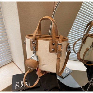 Detailed view of lychee texture leather bucket bag with fashion logo and heart charm