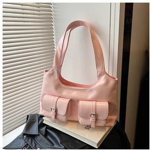 Close-up of pink glossy PU leather shoulder bag with buckle pockets and twin straps