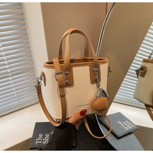 Detail of mini bucket bag showing lychee grain leather and heart pendant accessory