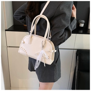Détail du cabas blanc avec couture tressée et pendentif en dentelle perlée sur mannequin