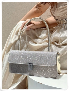 Detail of silver rhinestone evening clutch bag held by model in elegant satin dress