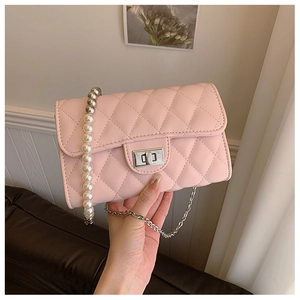 Détail du sac en cuir matelassé rose avec perles élégantes et chaîne en argent