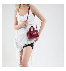 Close-up of red patent leather mini square crossbody bag with fashion branding