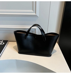 Classic black leather tote bag with minimalist large capacity design in a modern home setting