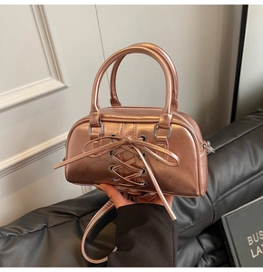 Dettaglio della borsa Boston metallizzata oro rosa con fiocco e doppi manici