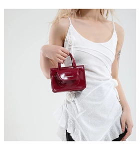 Detailed view of red patent leather mini crossbody bag with Fashion & Bags logo lettering