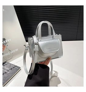 Detail der silbernen Mini-Tasche mit Spiegeleffekt, Magnetklappe und Metallbeschlägen