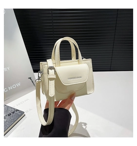Detail einer cremeweißen quadratischen Tasche mit Doppelgriffen und Fashion & Bags Text
