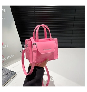 Detail der glänzenden rosa Umhängetasche mit Doppelgriffen und modischem Textaufdruck