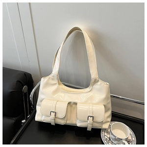 Detail of hobo bag featuring dual front pockets with silver buckles and a glossy finish
