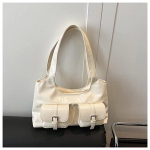 Detail view of cream white glossy PU leather bag with twin buckle flap pockets