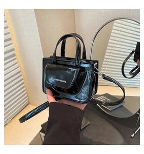 Detail of a mini black patent leather crossbody bag with Fashion & Bags lettering