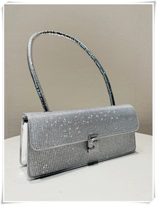 Detail of silver rhinestone evening bag with round handle and sparkling crystal texture