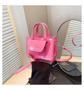 Detail of pink patent leather mini square handbag with silver hardware and fashion text