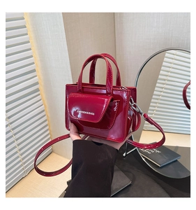 Detailed shot of red patent leather mini bag with silver buckles and fashion lettering