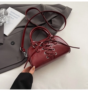 Dettaglio del design stringato bordeaux e occhielli in argento sulla borsa retrò