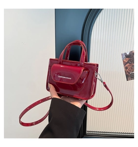 Close-up of a red patent leather mini crossbody bag with Fashion & Bags lettering