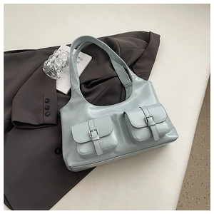 Detailed view of light blue tote bag with front flap pockets and metallic buckles