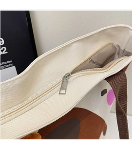 Detailansicht der weißen Canvas-Tasche mit Metallreißverschluss und braunen Webgriffen
